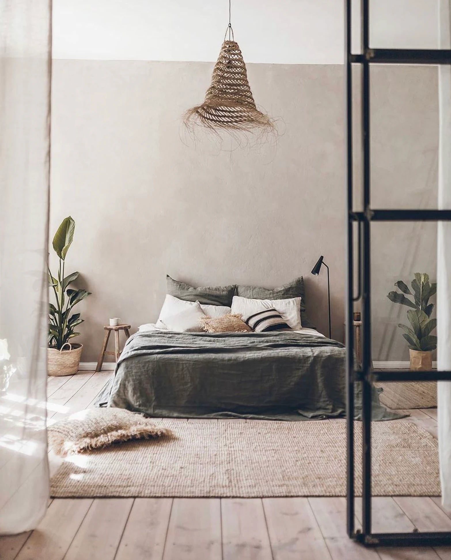 Bedroom with PītasLampas reed ceiling lamp, casting a warm glow.